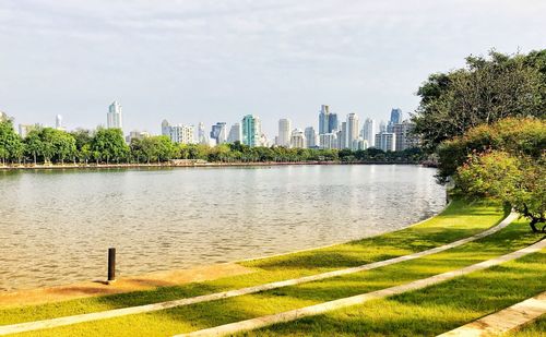 Scenic view of river by buildings against sky