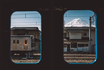 Train and snowcapped mountain seen through window