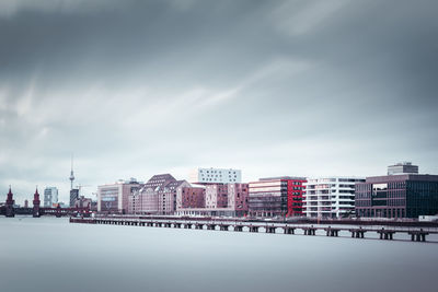 Buildings in city against cloudy sky