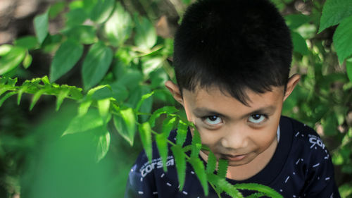 Portrait of boy by plants
