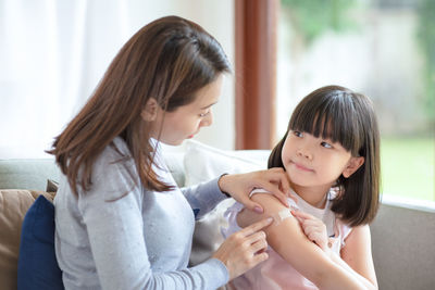 Mother and girl sitting at home