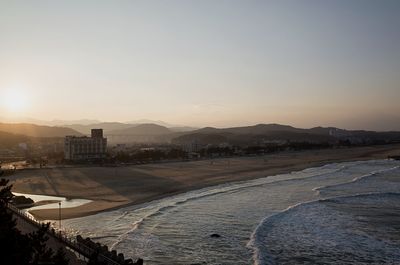 Scenic view of city against sky during sunset