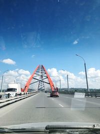 Bridge over road against sky seen through car windshield