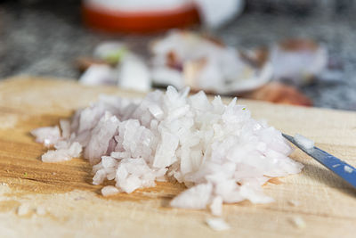 Chopped onion on wooden cutting board.