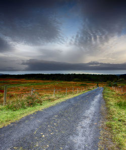 Road by landscape against sky