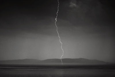 Lightning over sea against storm clouds