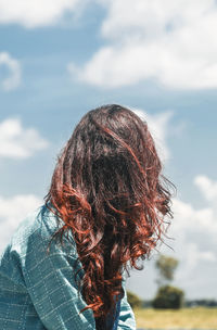 Woman looking away against sky