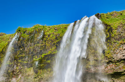 Low angle view of waterfall against sky