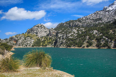 Scenic view of sea and mountains against sky