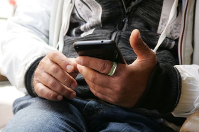 Midsection of man using mobile phone