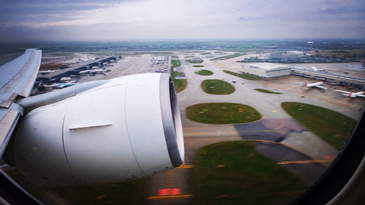 HIGH ANGLE VIEW OF AIRCRAFT WING AGAINST SKY