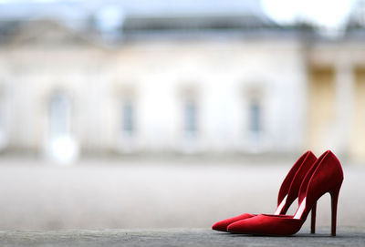 Close-up of red shoes on table against building