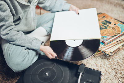 Young woman listening to music from vinyl record. retro and vintage style. hobby and passion