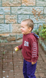 Portrait of cute boy standing on footpath