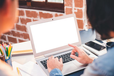 Low section of person using laptop on table