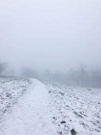 Scenic view of snow covered land against sky