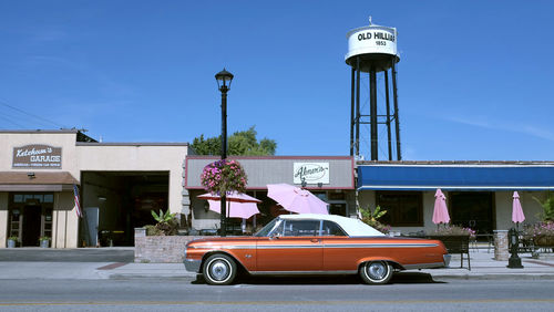 Car on street against buildings in city