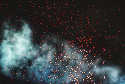 Low angle view of fireworks against sky at night