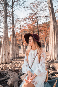 Young woman amidst trees in forest