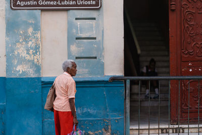 Rear view of man standing against door of building