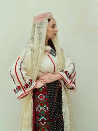 Young woman standing against wall