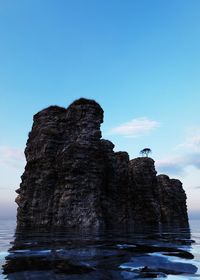 Rock formation on sea against blue sky