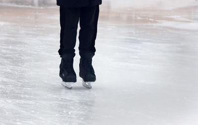 Low section of man walking on snow