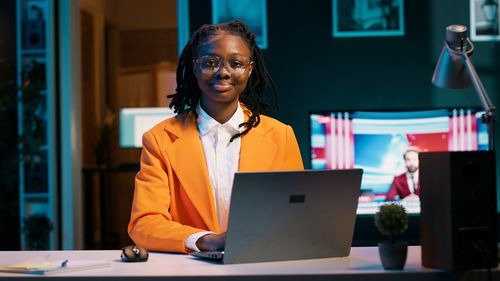 Portrait of young man using laptop at office