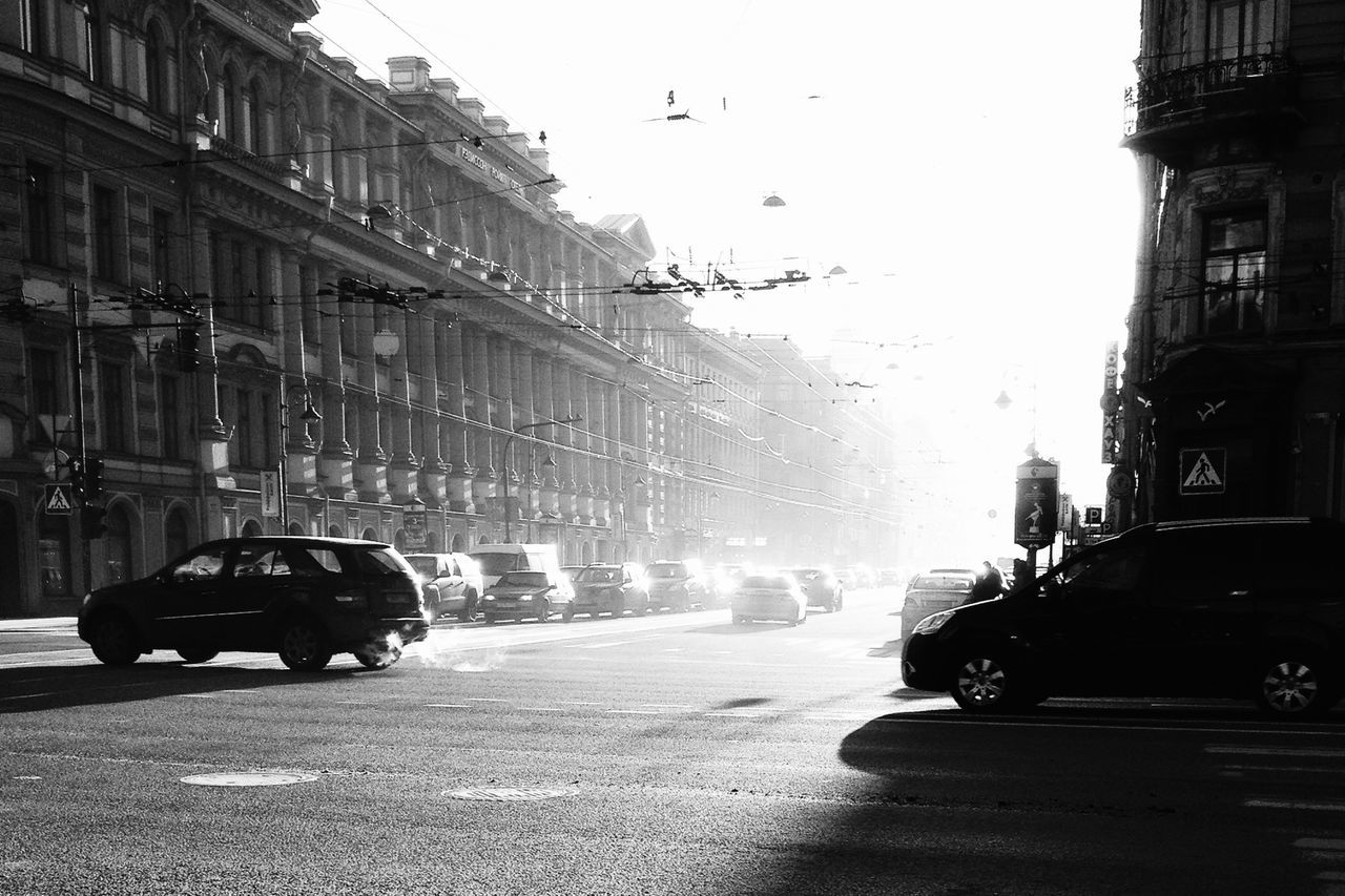 building exterior, car, architecture, land vehicle, built structure, street, transportation, mode of transport, city, city street, road, clear sky, city life, incidental people, building, men, the way forward, outdoors, day