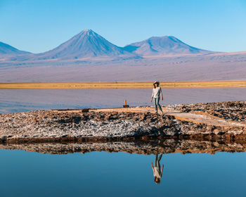 Scenic view of lake by mountains against sky