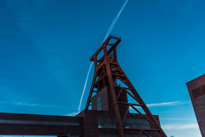 Low angle view of crane against blue sky
