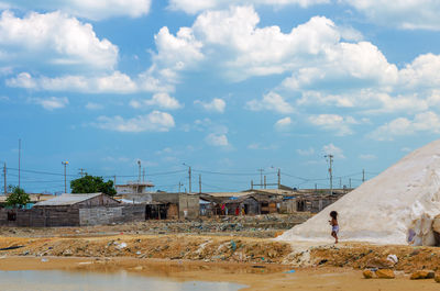 Slat flat by slum against cloudy sky