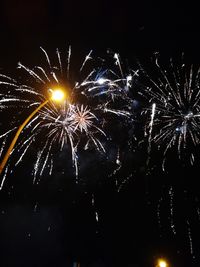 Low angle view of firework display at night