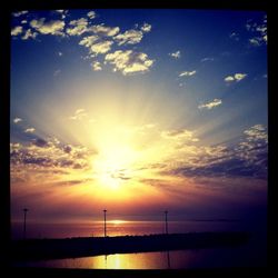 Sun shining through clouds at sunset