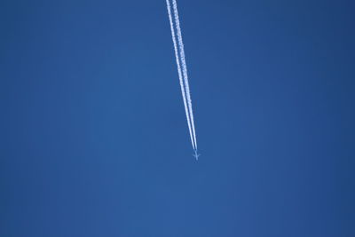 Low angle view of vapor trail against blue sky