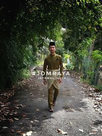 Full length portrait of young man standing in park