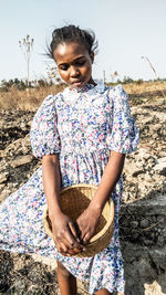 Portrait of young lady standing on field