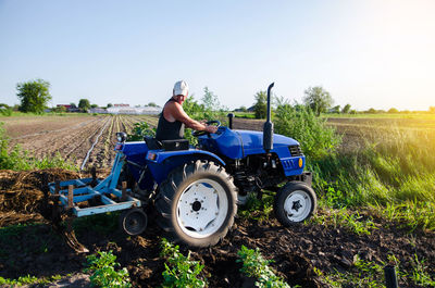 The farmer works in the field with a tractor. agroindustry and agribusiness. 