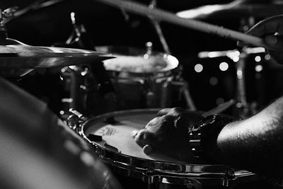 Cropped hand of man on drum at night