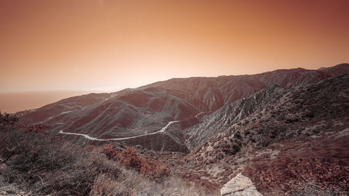 Scenic view of arid landscape against sky during sunset