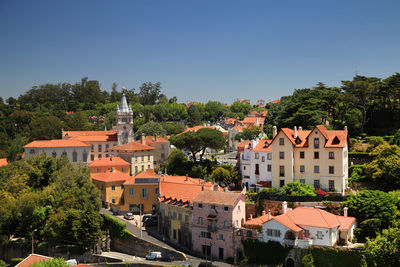 Buildings in town against clear blue sky