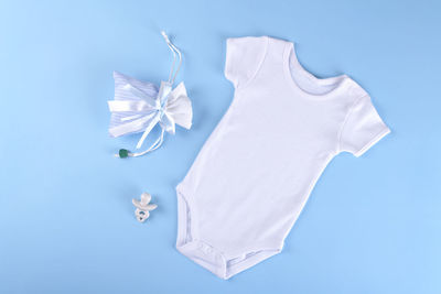 White baby shirt bodysuit on a blue background, for boys. mock up for design and placement of logos