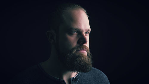 Portrait of mid adult man against black background