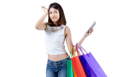 Portrait of young woman using smart phone against white background