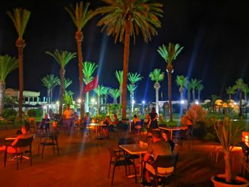 Empty chairs and tables at restaurant at night