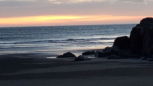Scenic view of beach against sky during sunset