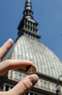 Hand holding tower of building