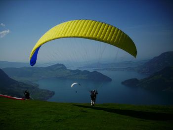 Person paragliding over mountain landscape