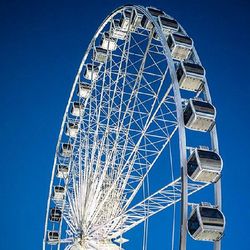 Low angle view of ferris wheel against blue sky