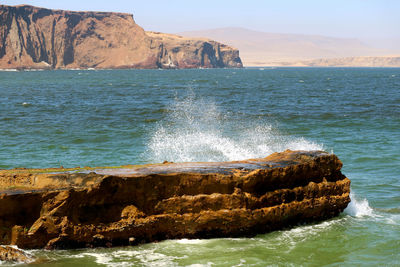 The wave crashing the rock in the pacific ocean, paracas national reserve, ica region of peru